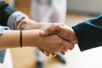 Two people shaking hands in a professional setting